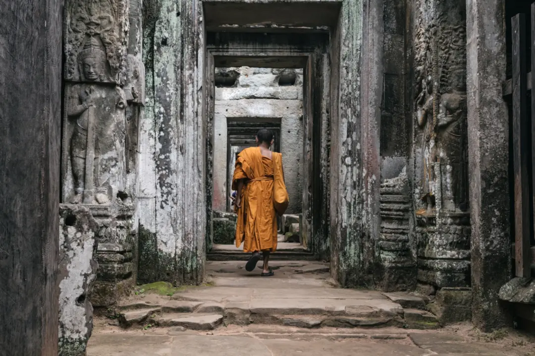 Un homme de dos dans un grand couloir d'un temple au Cambodge