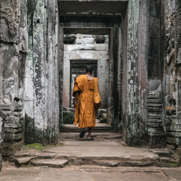 Un homme de dos dans un grand couloir d'un temple au Cambodge