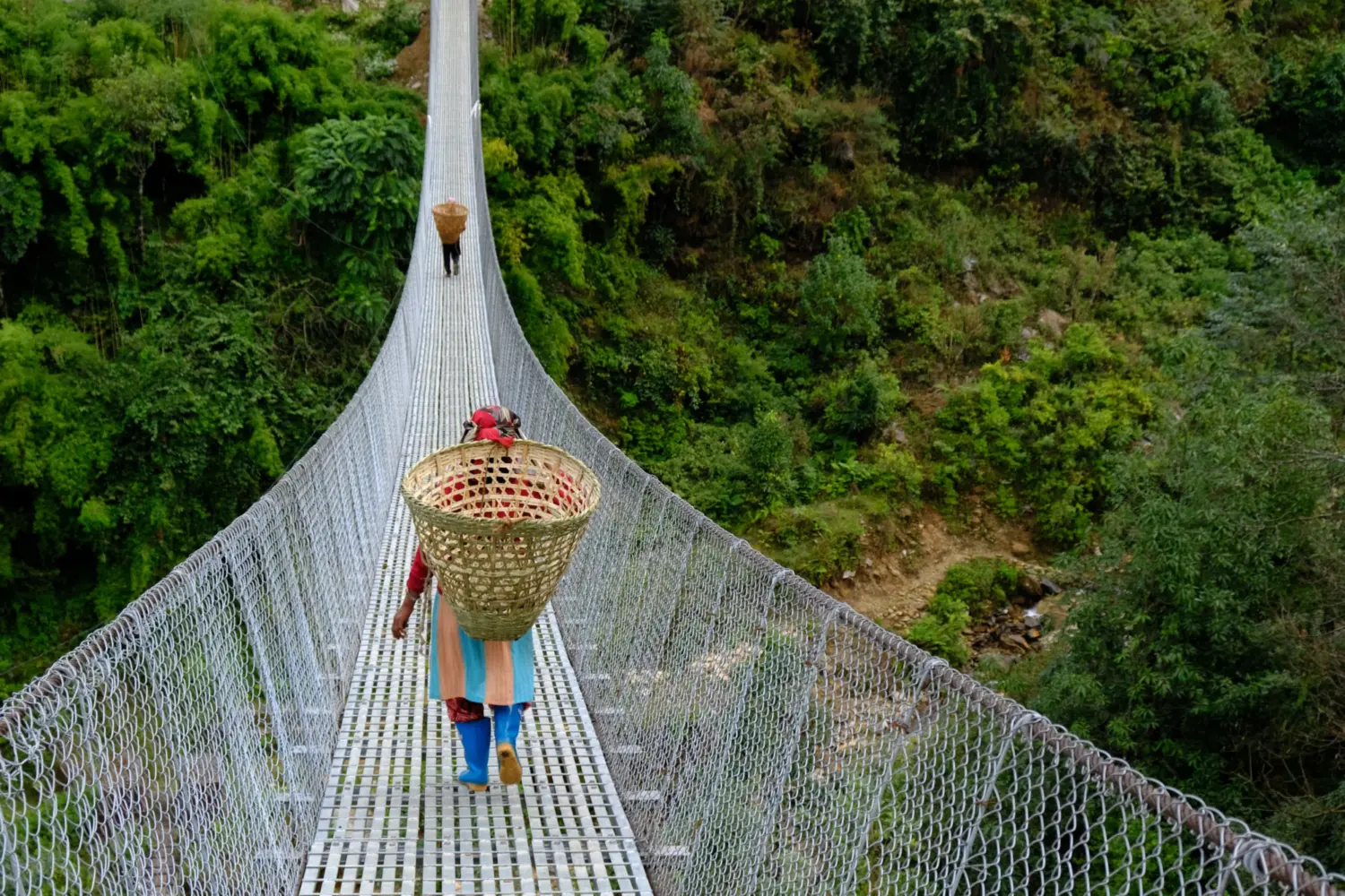 Une femme traversant un pont suspendu dans la région de l'Everest au Népal.