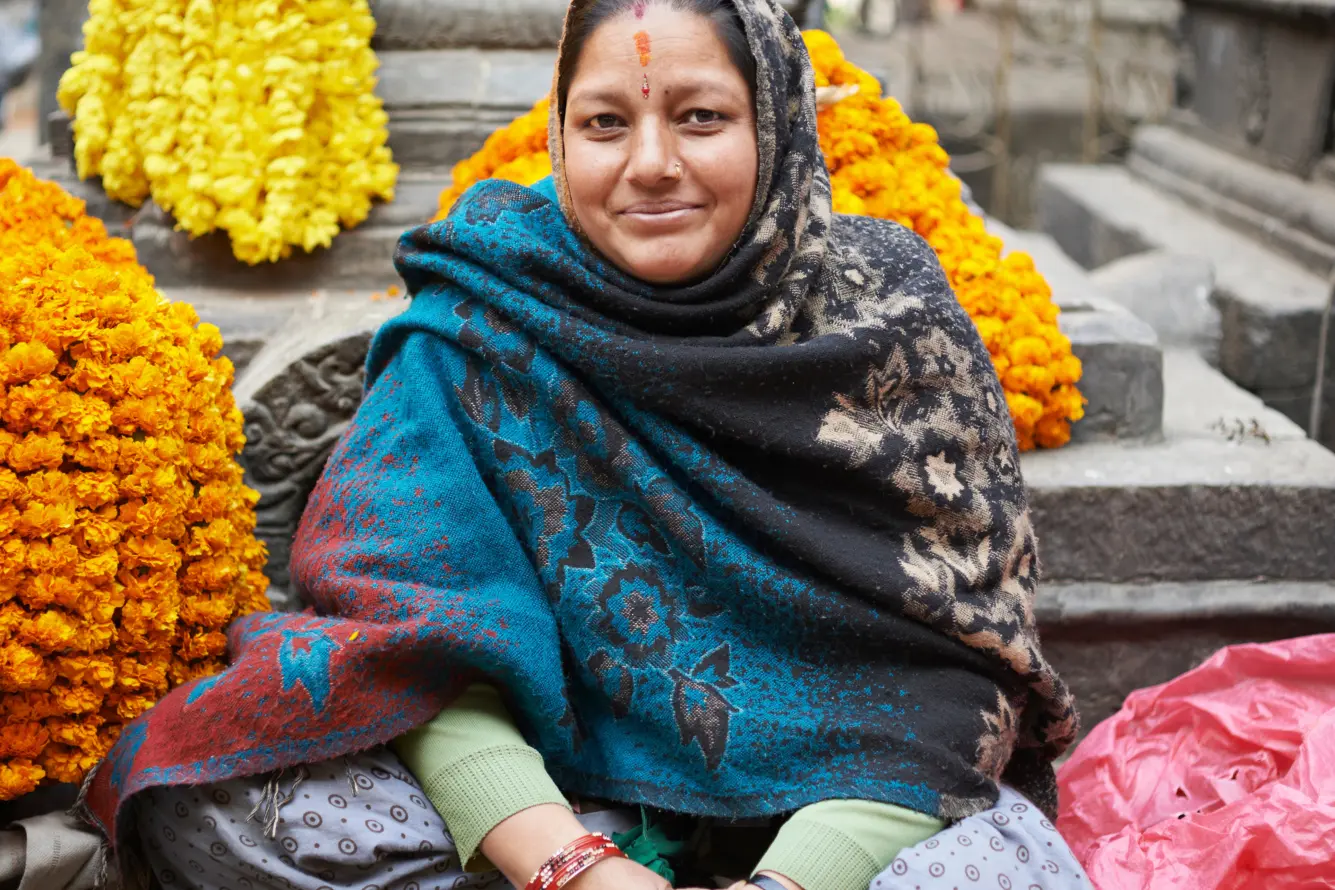 Une femme parmi des guirlandes de fleurs à Katmandou au Népal