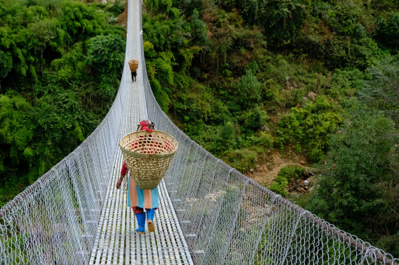 Une femme traversant un pont suspendu dans la région de l'Everest au Népal.