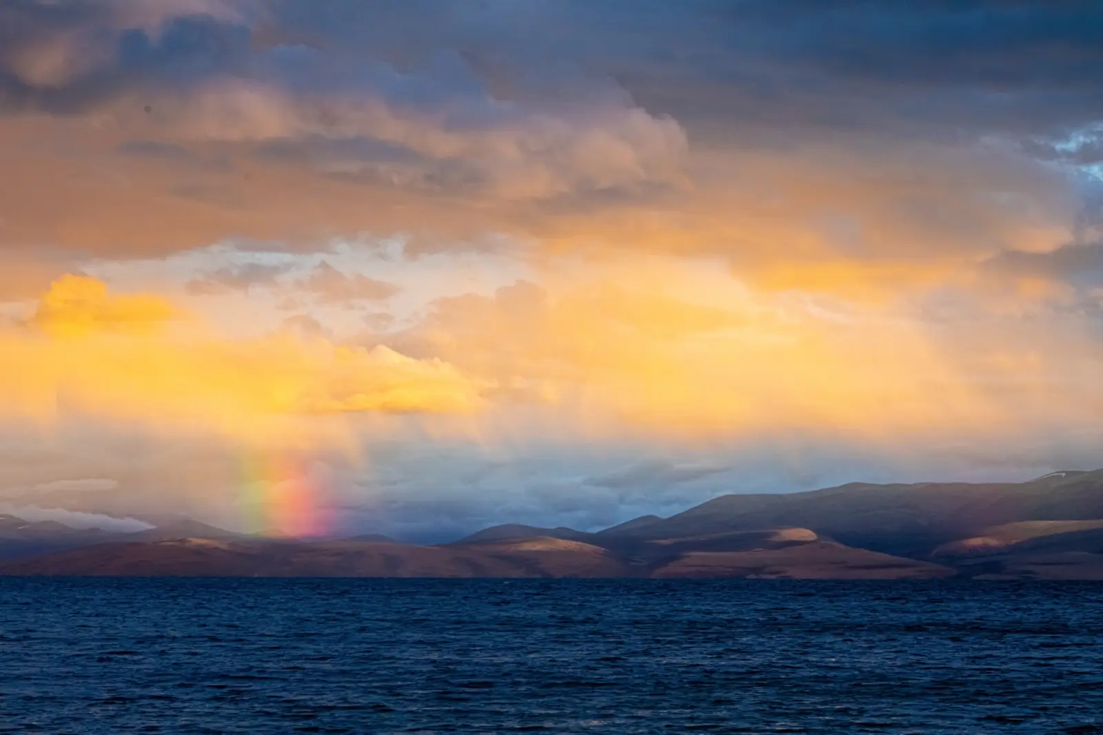 Le lac Manasarovar au Tibet, avec des rayons de soleil qui percent les nuages