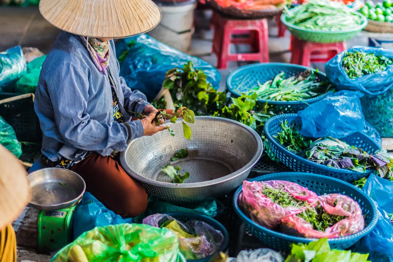 Une femme qui vend dans un marché de rue animé au Vietnam.