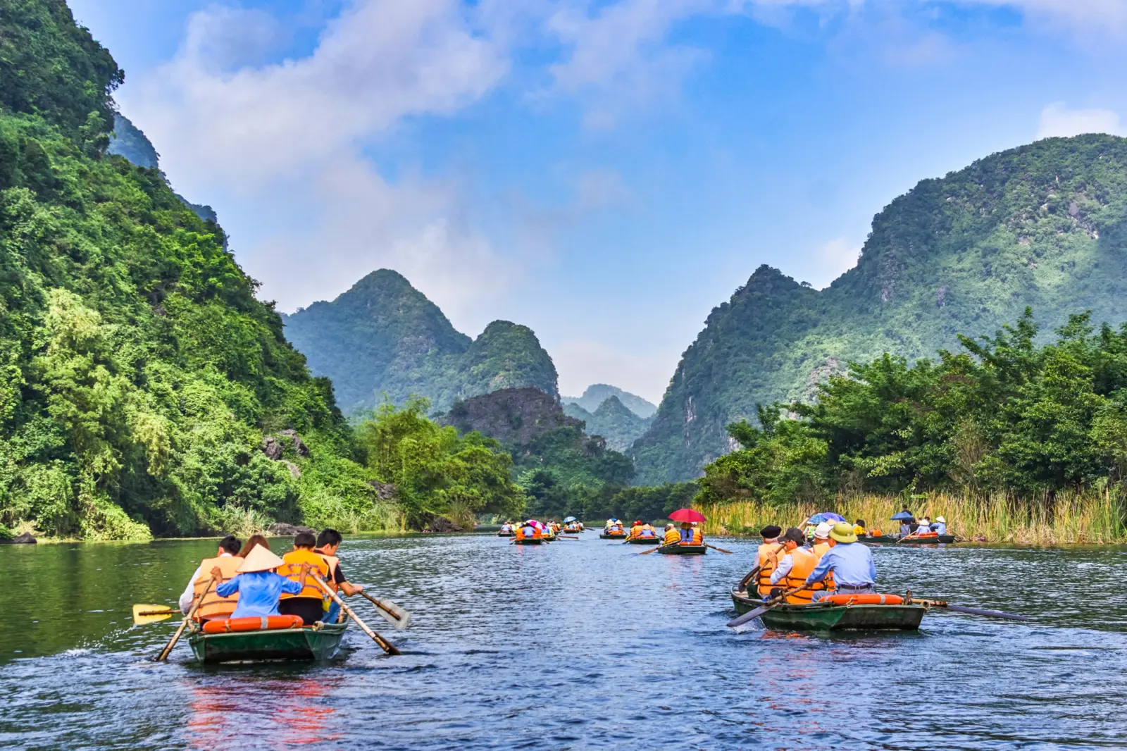 Voyageurs à bord de canots sur les rivières de la Baie d'Halong terrestre