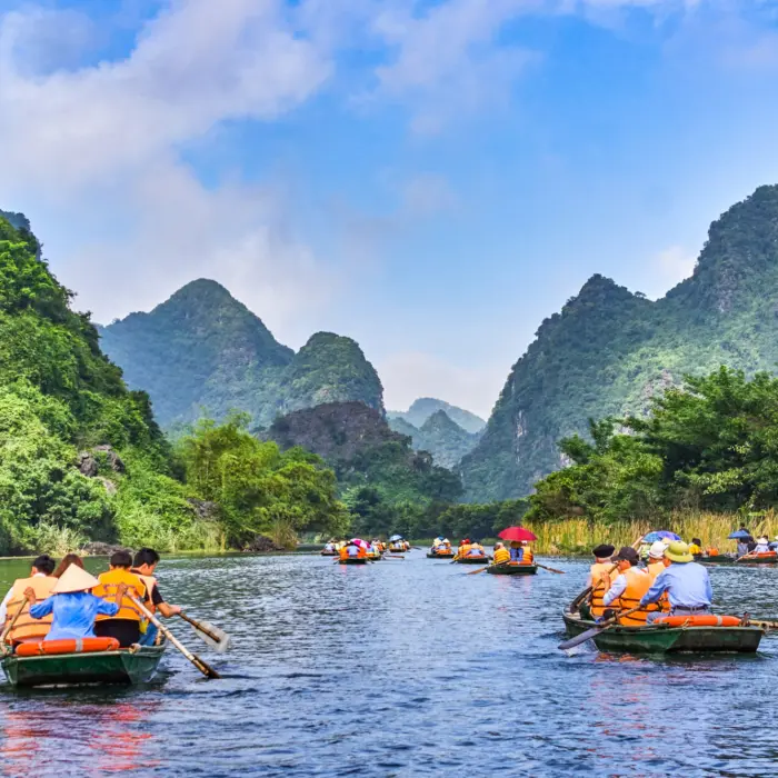 Voyageurs à bord de canots sur les rivières de la Baie d'Halong terrestre