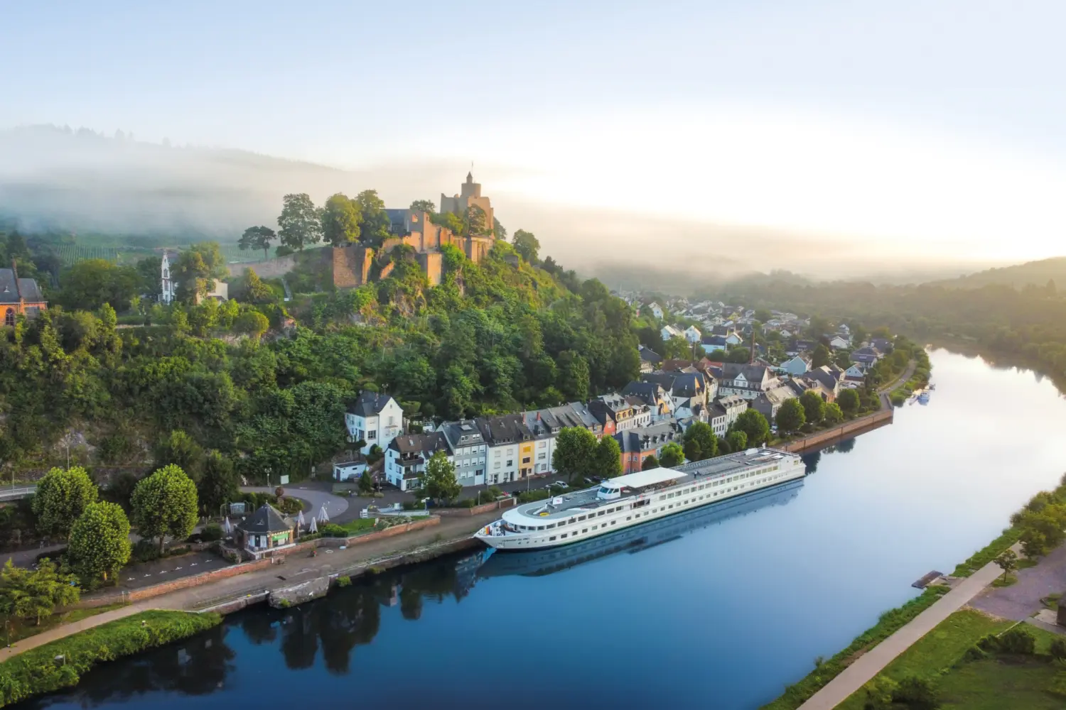 Vue extérieure sur le MS Leonardo da Vinci de CroisiEurope naviguant sur La Sarre avec en arrière-plan le château de Sarrebourg