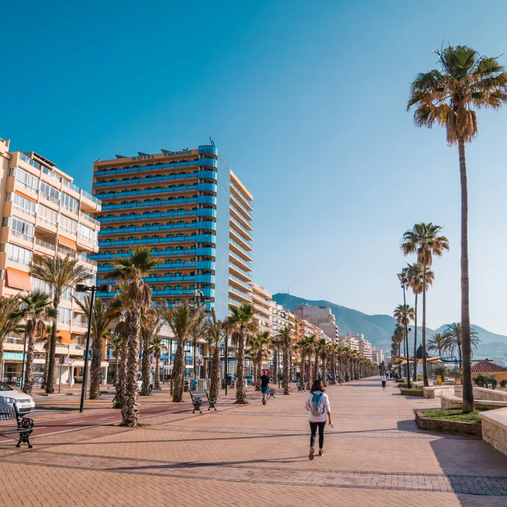 La promenade en bord de mer de Fuengirola, en Espagne, avec des palmiers et des hôtels en arrière-plan.