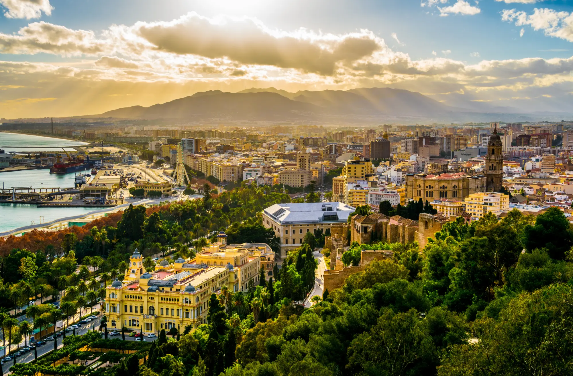 Vue aérienne de Malaga prise depuis le château de gibralfaro comprenant le port de Malaga, le château d'Alcazaba et la cathédrale de Malaga pendant le coucher du soleil