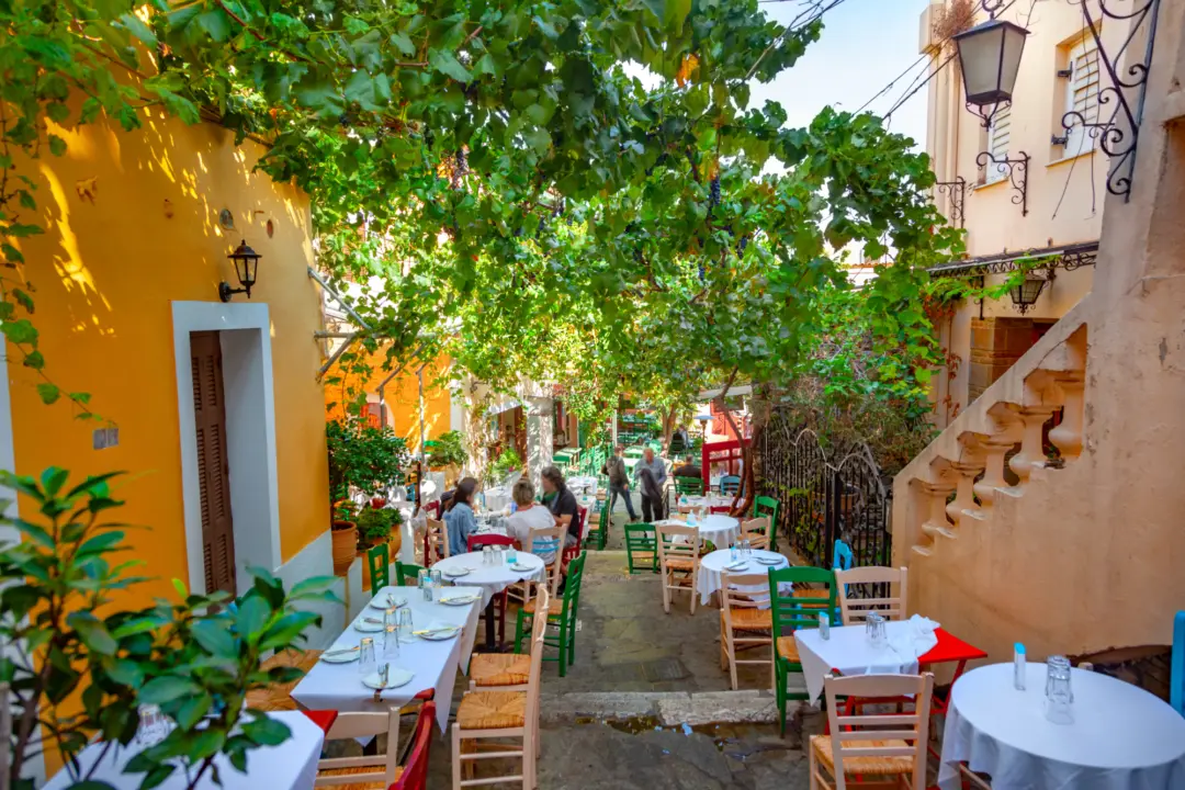Vue sur l'une des petites rues du quartier la Plaka à Athènes avec ses cafés et terrasses