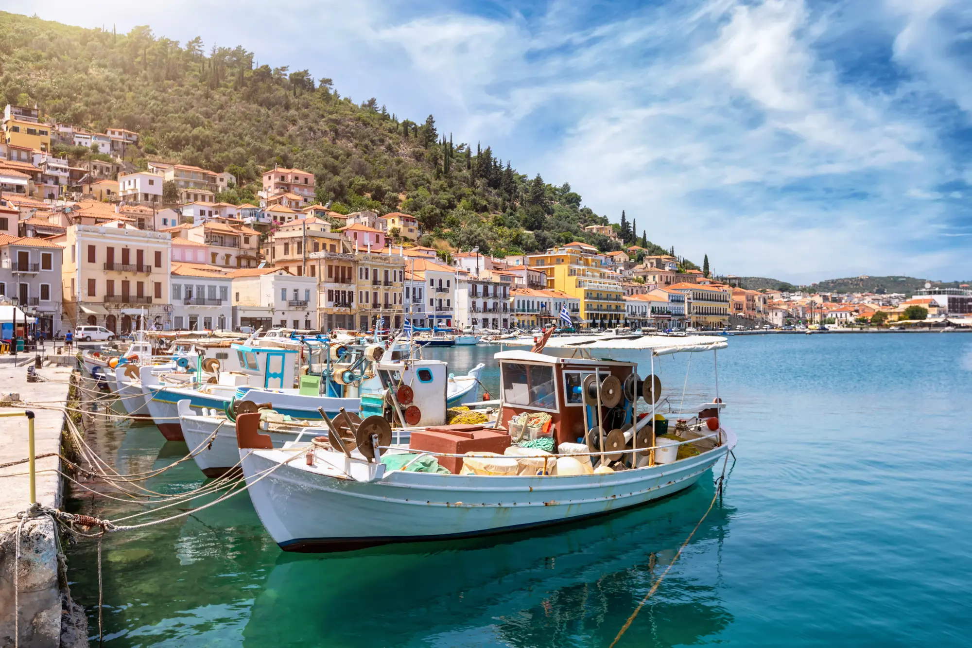 Vue sur la pittoresque ville de Gythion, dans le Péloponnèse, en Grèce, avec un bateau de pêche traditionnel et de belles maisons alignées sur la colline