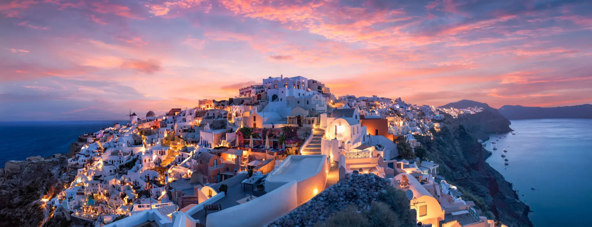 Vue sur la ville d'Oia à Santorin dans les îles grecques sous un ciel rose