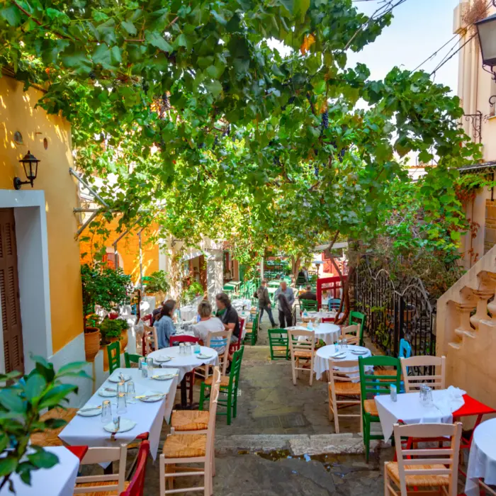 Vue sur l'une des petites rues du quartier la Plaka à Athènes avec ses cafés et terrasses