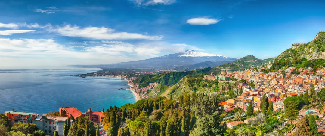 Vue aérienne sur la ville de Taormine et le volcan Etna, avec son sommet enneigé, située en Sicile en Italie