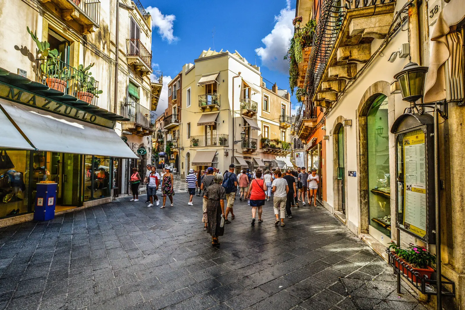 Personnes se promenant dans une rue à Taormina.