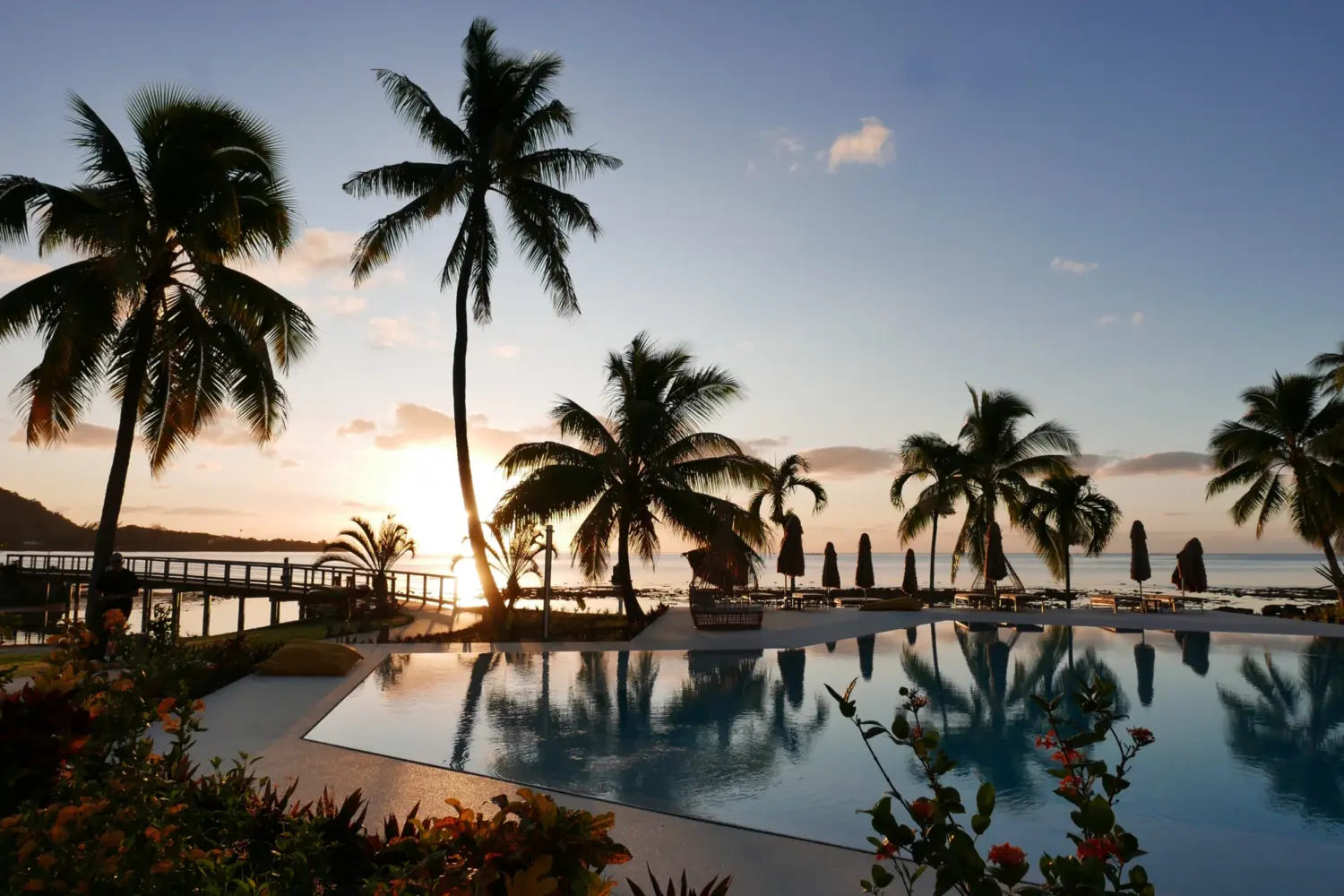 Coucher de soleil sur une piscine et des palmiers à Moorea
