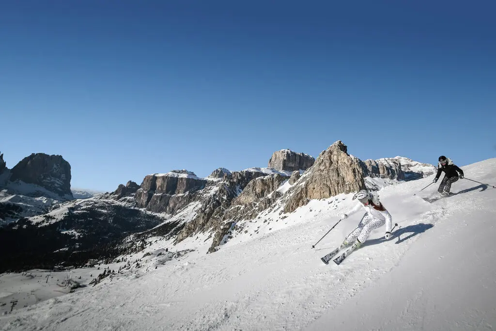 Deux skieuses qui dévalent les pentes de la station de ski Canazei en Italie