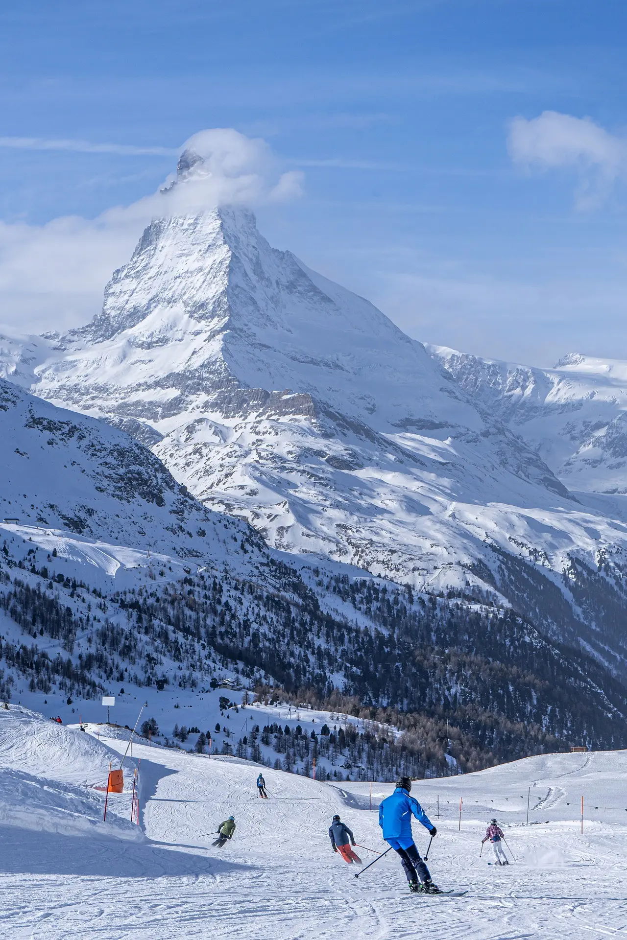 Skieurs qui dévalent les pistes à Zermatt avec vue sur le Cervin