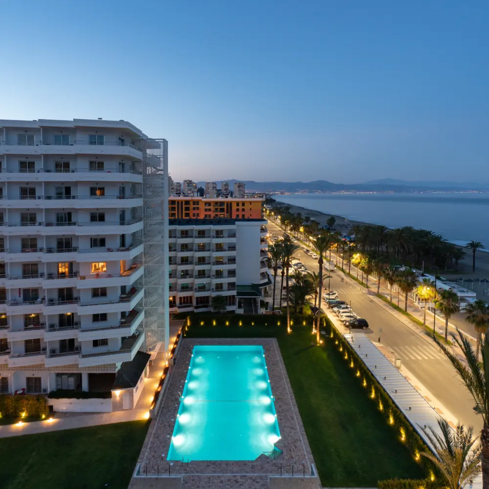 Vue en soirée sur le grand hôtel Bajondillo à Torremolinos en Espagne et sa piscine turquoise qui sont face à la mer Méditerranée de la Costa del Sol