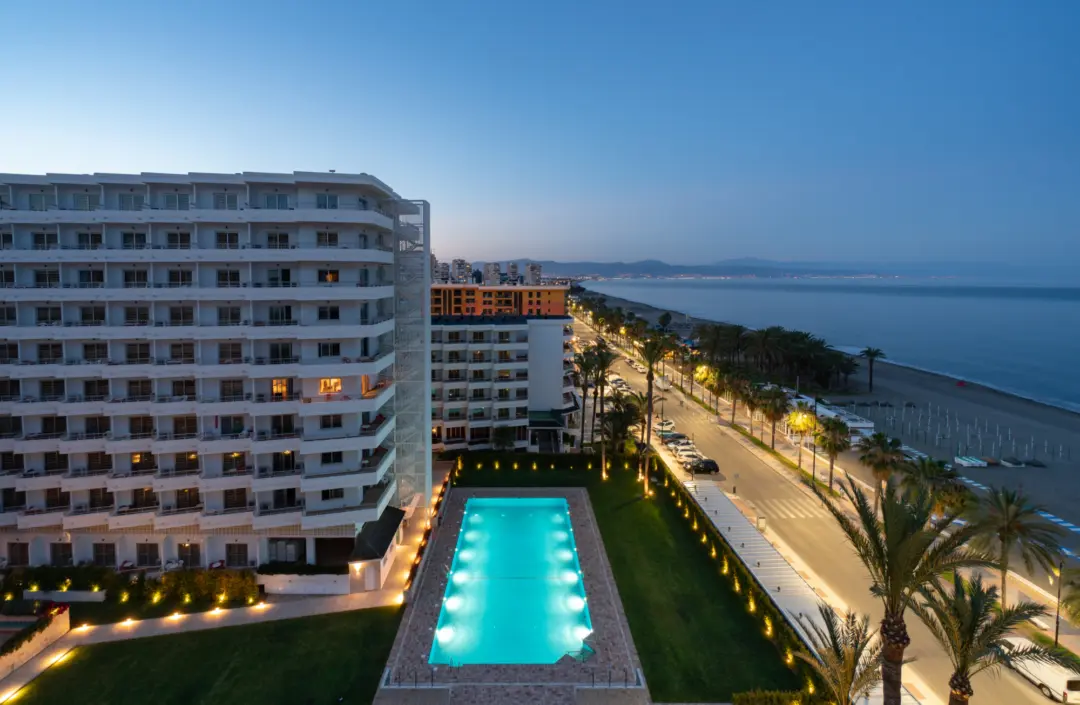 Vue en soirée sur le grand hôtel Bajondillo à Torremolinos en Espagne et sa piscine turquoise qui sont face à la mer Méditerranée de la Costa del Sol