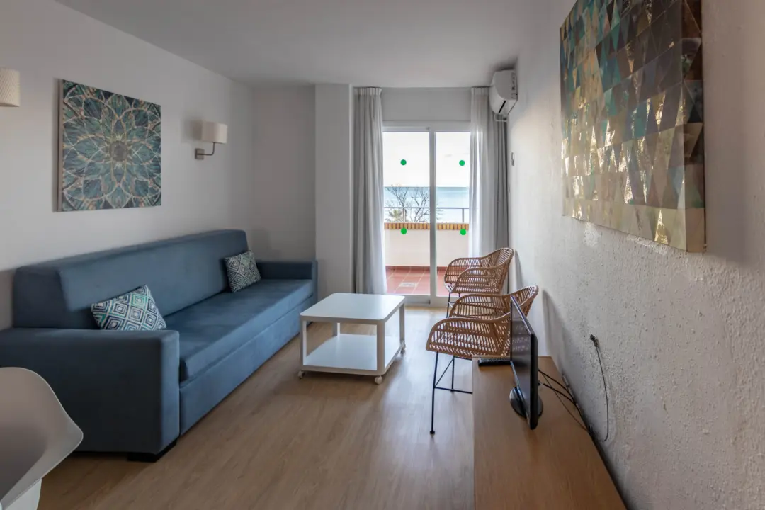 Salon d'un appartement avec sofa, chaises et balcon offrant une vue sur la mer Méditerranée à l'hôtel Buensol sur la Costa del Sol