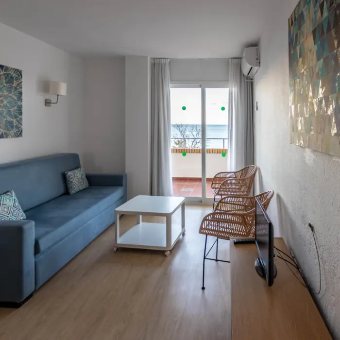 Salon d'un appartement avec sofa, chaises et balcon offrant une vue sur la mer Méditerranée à l'hôtel Buensol sur la Costa del Sol