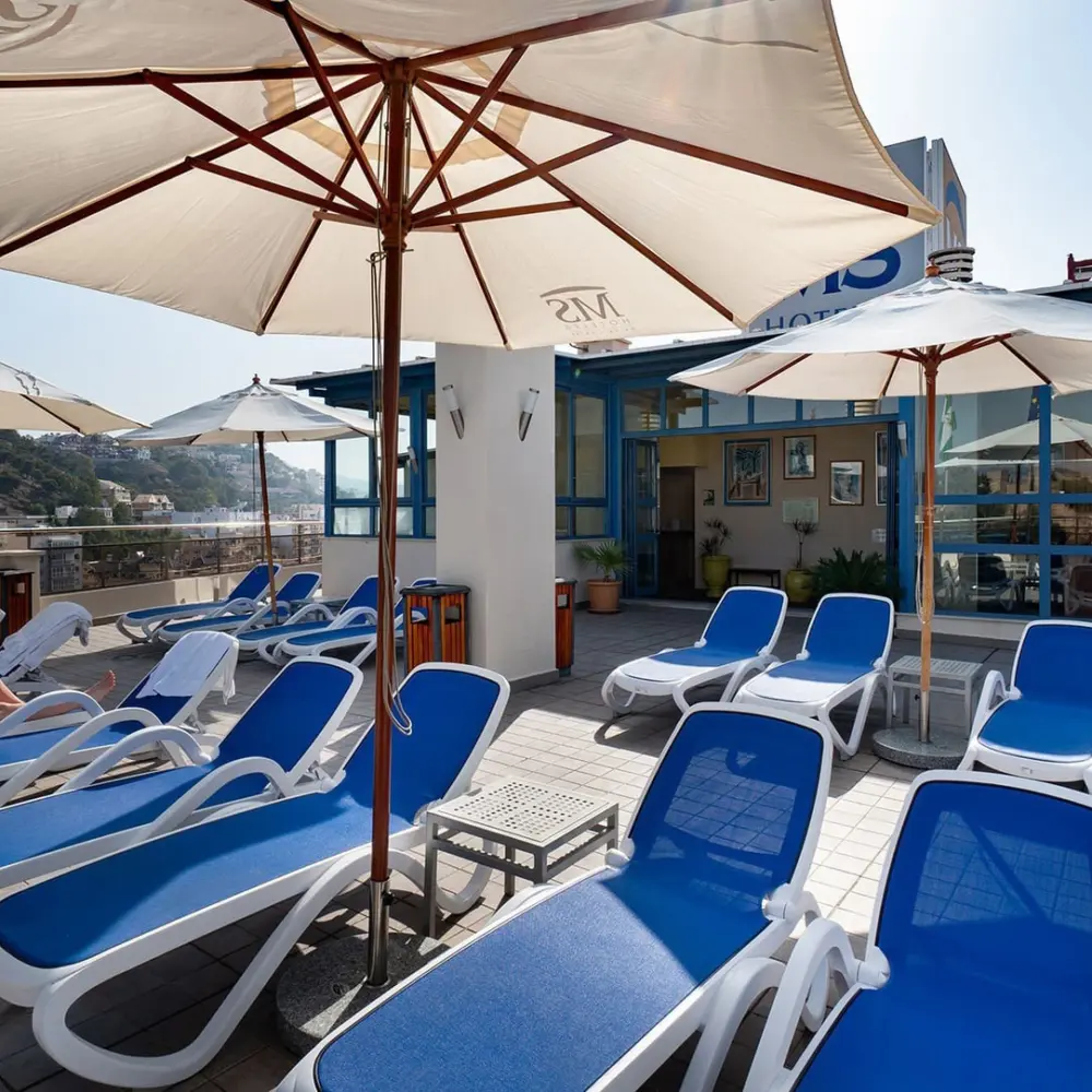 La terrasse située sur le toit de l'hôtel MS Maestranza Malaga Centre avec ses chaises longues sous un ciel ensoleillé