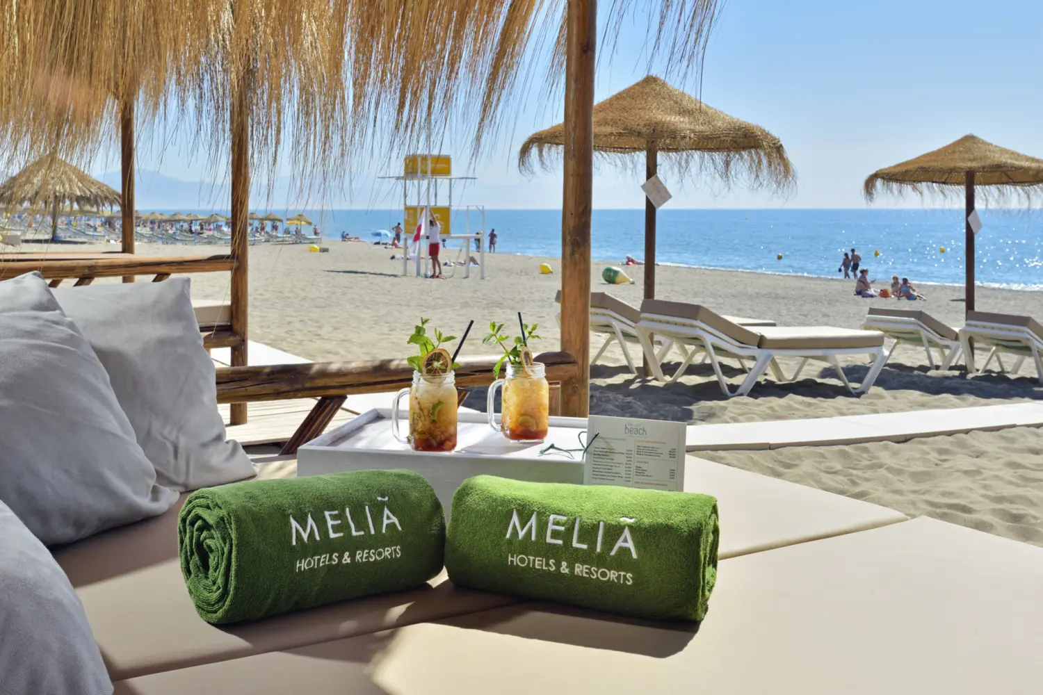Un lit avec boissons sur la plage de sable de Torremolinos à l'hôtel Meliá Costa del Sol