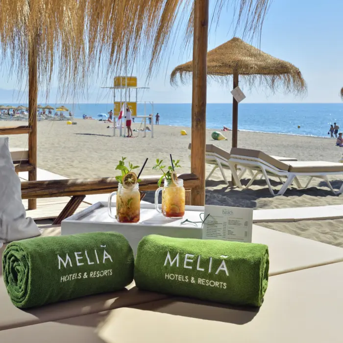 Un lit avec boissons sur la plage de sable de Torremolinos à l'hôtel Meliá Costa del Sol