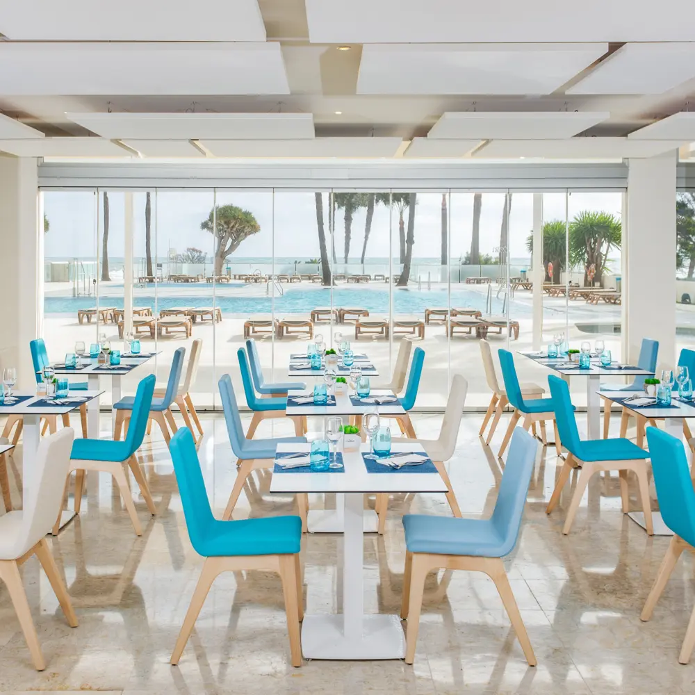 Une salle à manger d'un restaurant avec vue sur la piscine et la mer à l'hôtel Ocean House Costa del Sol à Torremolinos