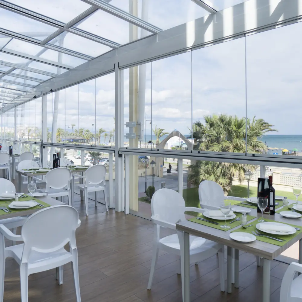 Une salle de restaurant avec mur vitré qui offre une vue sur la mer