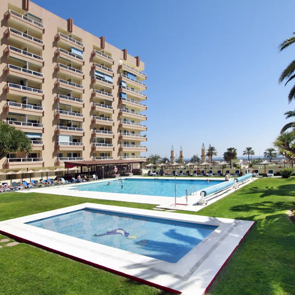 Deux piscines entourées de gazon à l'hôtel Pyr Fuengirola à Fuengirola