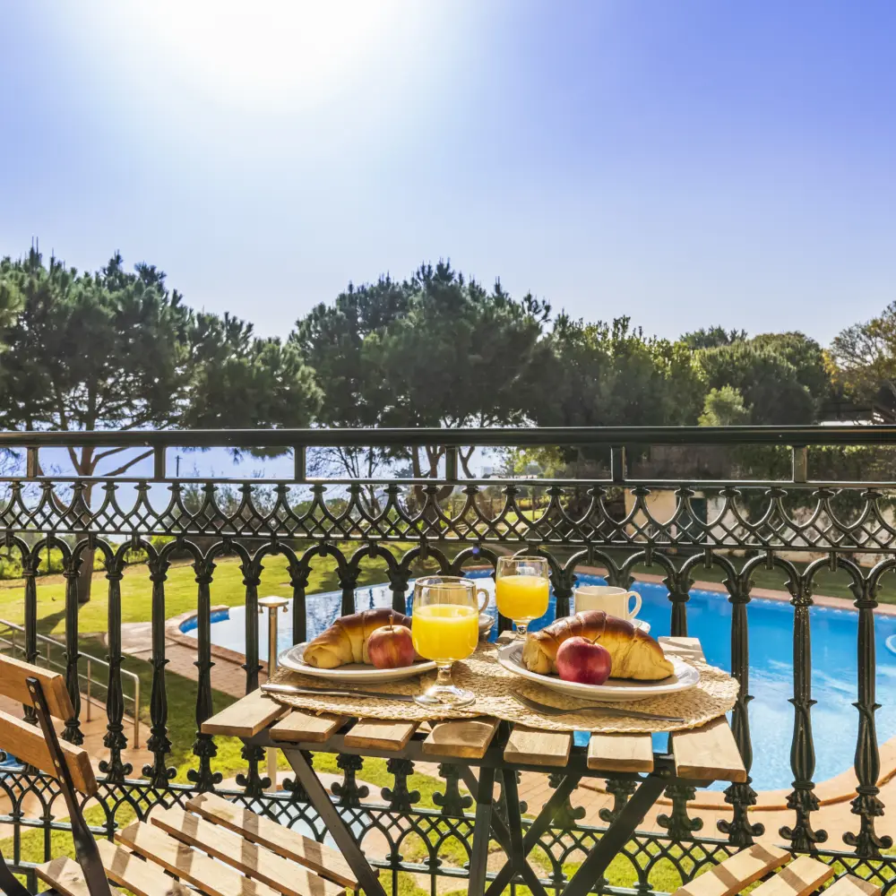 Déjeuner sur un balcon avec vue sur la piscine de l'hôtel Quinta Pedra dos Bicos à Albufeira au Portugal